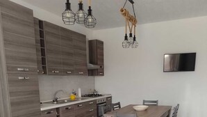 Une cuisine moderne avec des meubles en bois, une table à manger et un sol à carreaux.