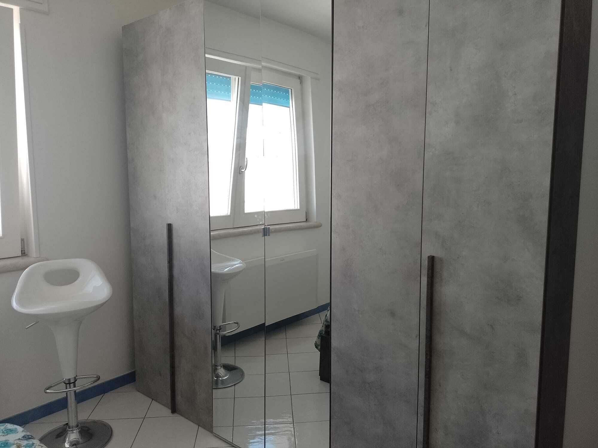 Une salle de bain avec des toilettes, un lavabo et une fenêtre.