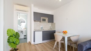 Una cucina moderna con forno a microonde, lavello e zona pranzo con tavolo e sedie.