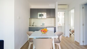 A modern kitchen with a microwave, sink, and a bowl of fruit on the table. - Modern apartment. Swimming pool and beachfront. Corralejo (Corralejo)