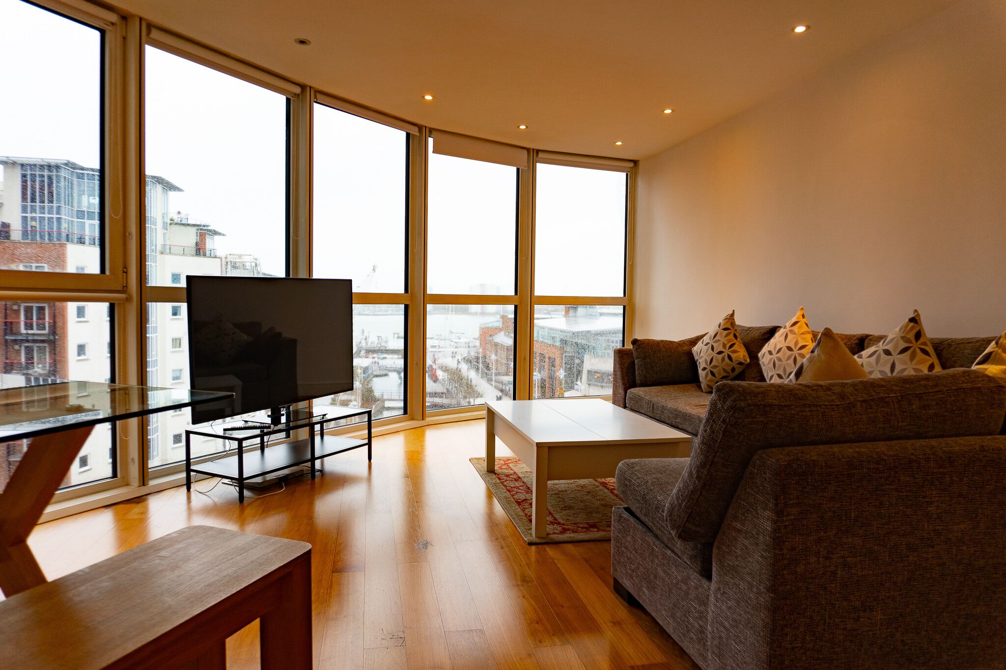 A modern living room with a large TV, a sofa, and a coffee table.