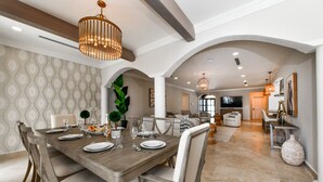 Un comedor con una mesa de madera dispuesta para cuatro personas, rodeada de sillas.