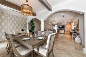 A dining area with a wooden table set for four, surrounded by chairs. - Charming 5BR Pool Home w Patio near Beaches, Aruba (Noord)
