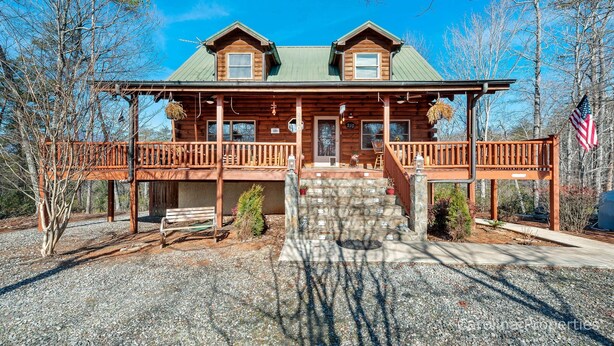 A log cabin with a porch, a front door, and a small front yard. - Hot Tub, Mirror Lake Access, Fireplace - Outlander Cabin by Carolina Properties (Lake Lure)