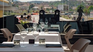 A restaurant table set with wine glasses and a digital clock displaying 14. - Hotel Amiternum (L'Aquila)