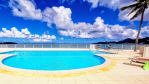 Une piscine avec vue sur la mer et les montagnes en arrière-plan.