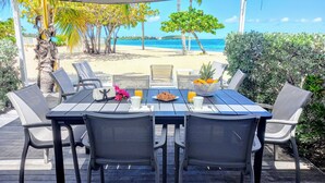 Une terrasse avec une table préparée pour le petit-déjeuner, donnant sur une plage.
