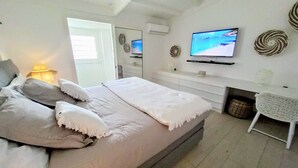 Une chambre à coucher avec un lit, une télévision, un miroir et une petite table.