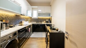 A compact kitchen with modern appliances, a built-in oven, and a microwave. - 2br renovated flat close to metro (Athens)