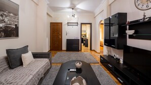 A modern living room with a sofa, coffee table, and TV stand. - 2br renovated flat close to metro (Athens)