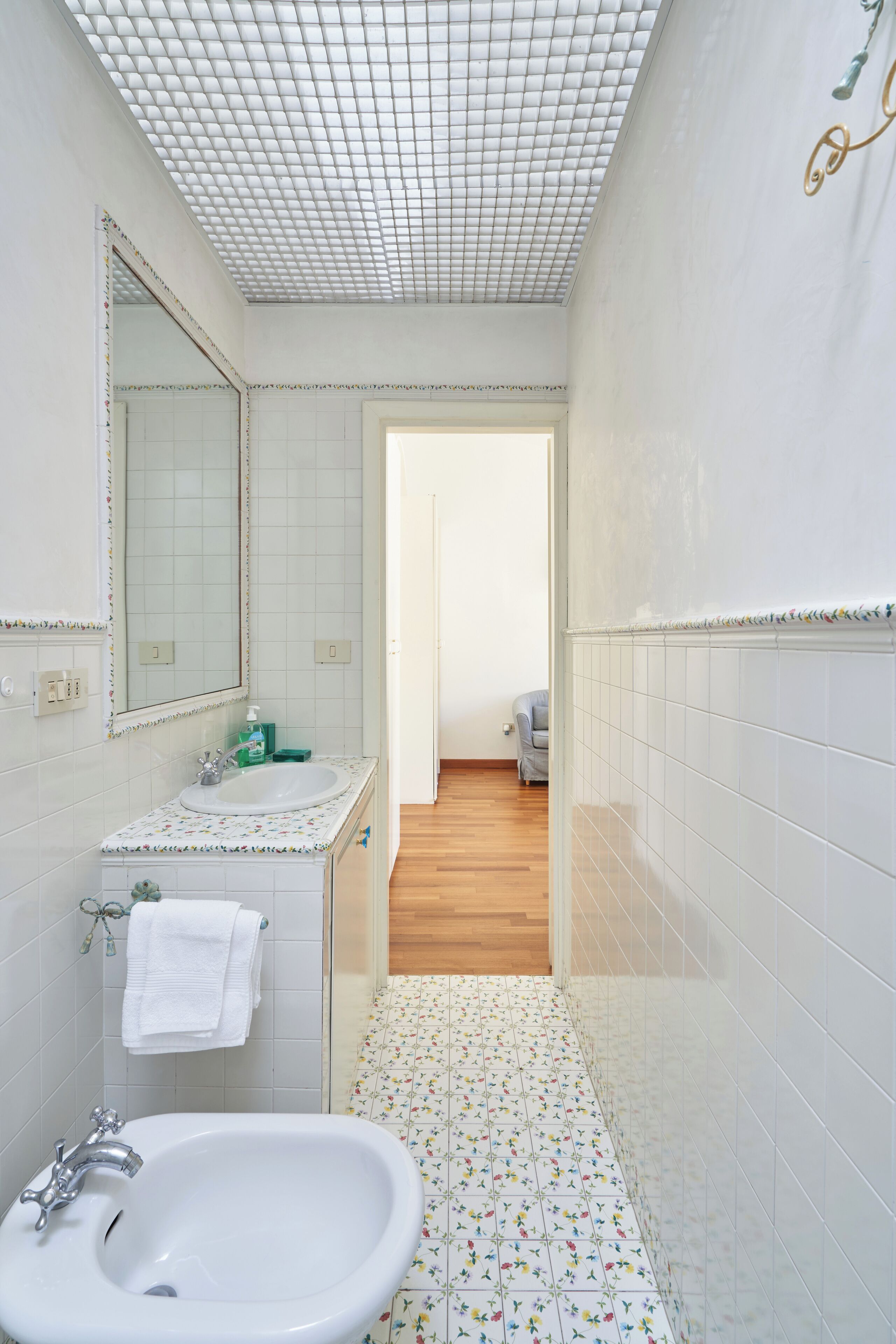 Ein Badezimmer mit Waschbecken, Spiegel und Fliesenboden.