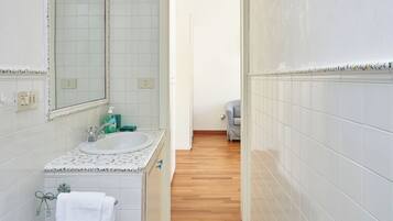 Ein Badezimmer mit Waschbecken, Spiegel und Fliesenboden.