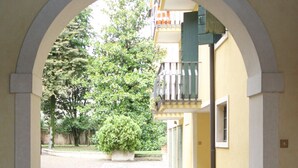 An arched corridor with a tiled floor leading to a building with a balcony. - Casa Ambra tranquility in the city center ⭐️⭐️⭐️⭐️⭐️ (Padova)