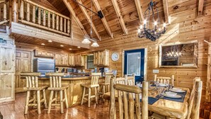 Un interno rustico con zona pranzo in legno, un bancone e una cucina.
