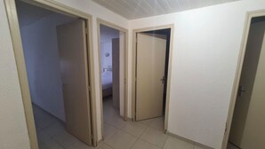 A corridor with three doors leading to different rooms. - Apartment near the beach and local shops in a quiet neighborhood (Saint-Cyprien)