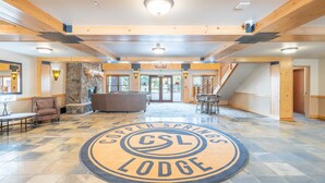 A spacious lobby with a central circular emblem reading "Copper Springs Lodge." - Steps away from Super Bee Lift, wifi, underground parking (Copper Mountain)