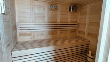 A sauna with wooden slatted floors and walls, a bench, and a small heater.