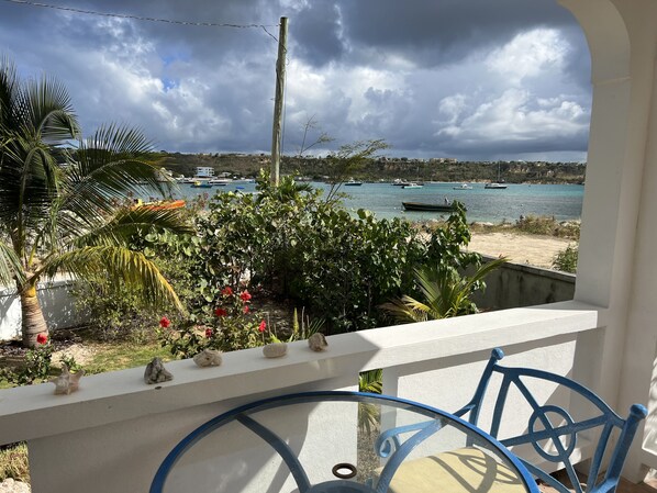 A balcony with a view of a beach and boats.
