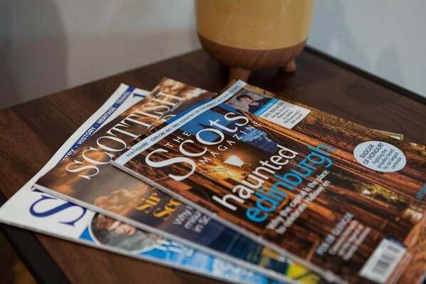 Three magazines on a wooden table. - Captivating 3-bed Apartment by Gleneagles (Auchterarder)