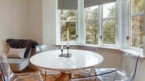 A room with a round table, a chair, and a window with curtains. - Captivating 3-bed Apartment by Gleneagles (Auchterarder)