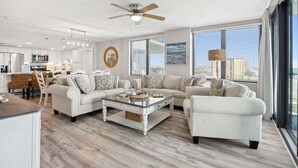 A modern living room with a sofa set, a coffee table, and a ceiling fan.