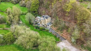 A large, historic house surrounded by lush greenery and a winding path. - Belvedere Farm (Halifax)