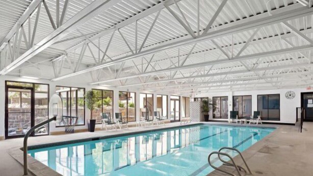 Piscina interior con techos altos y ventanas amplias.