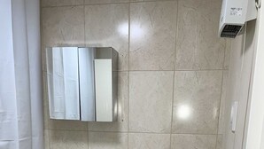 Et badeværelse med vask, toilet og spejl.