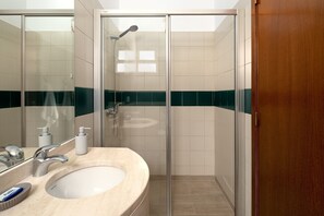 Een douche, een haardroger, handdoeken, toiletpapier