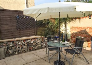 Enjoy a romantic dinner for two on the patio, surrounded by lush surroundings and a fence.