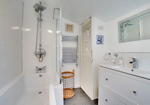 Enjoy a refreshing shower or soak in the standalone bathtub in this bathroom, featuring a walk-in shower with handheld showerhead and wall-mounted faucet.