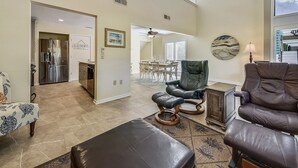 A spacious living area with a high ceiling, a dining area, and a kitchen with a stainless steel refrigerator. - Spacious Pup Friendly Villa w/ Golf Course Views (Hilton Head Island)