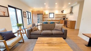 Un salon moderne avec un canapé, une table basse et un coin repas.
