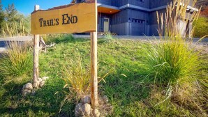 Un bâtiment moderne, sur lequel on peut lire l’inscription « Trail’s End », entouré d’herbe et de rochers.