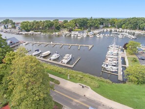 A marina with multiple docks and boats, surrounded by greenery and a clear sky. - Steps Away (South Haven)