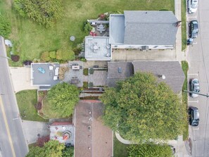 An aerial view of a residential area with a house featuring a patio, a garage, and a driveway.