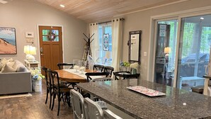 Eine moderne Küche mit einer Granit-Arbeitsplatte, Holzböden und einem Essbereich mit einem Holztisch und Stühlen.