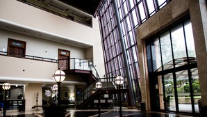 A spacious lobby with a grand staircase, large windows, and a reception desk. - Summit Flat Service São José dos Campos (São José dos Campos)