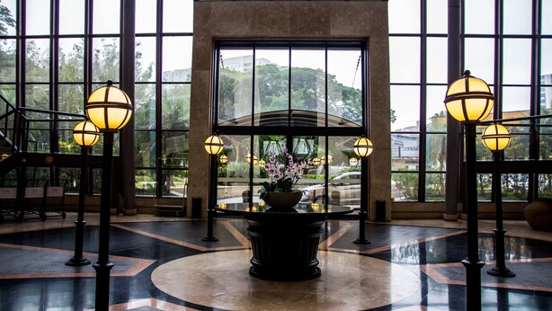 A lobby with large windows, a central flower arrangement, and multiple floor lamps. - Summit Flat Service São José dos Campos (São José dos Campos)