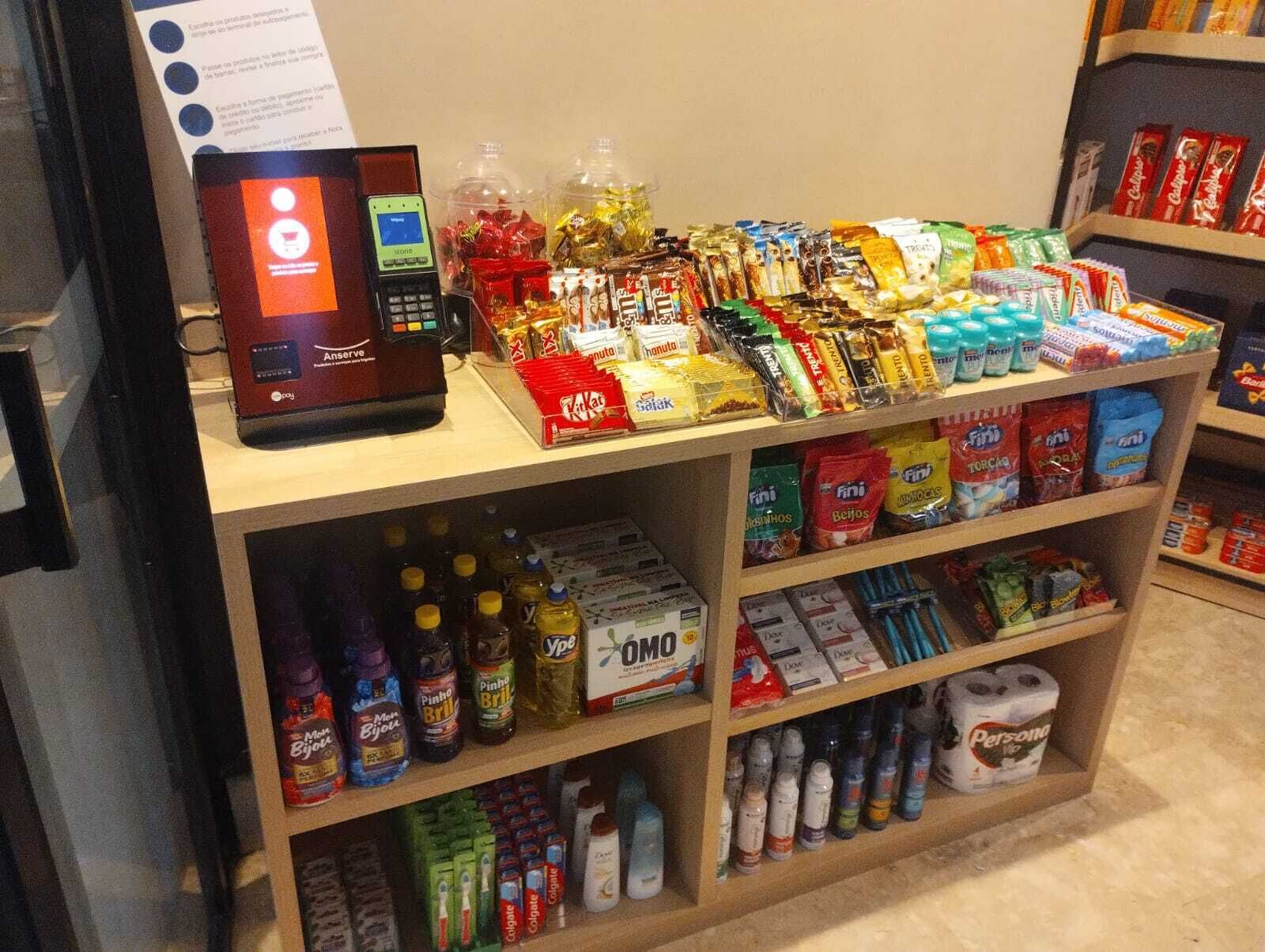 Un distributeur automatique proposant une variété de collations et de boissons, notamment des chips, des chocolats et des boissons en bouteille.