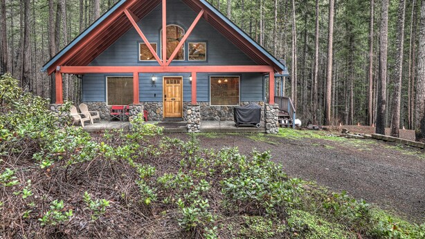 Une cabane avec des fondations en pierre, une porte en bois et un toit rouge.