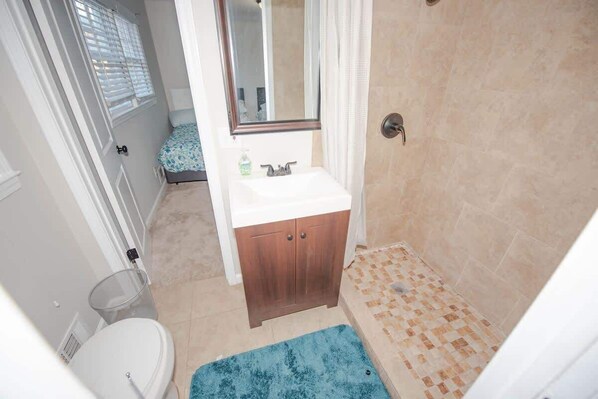 Une salle de bain avec une douche, un lavabo et des toilettes.