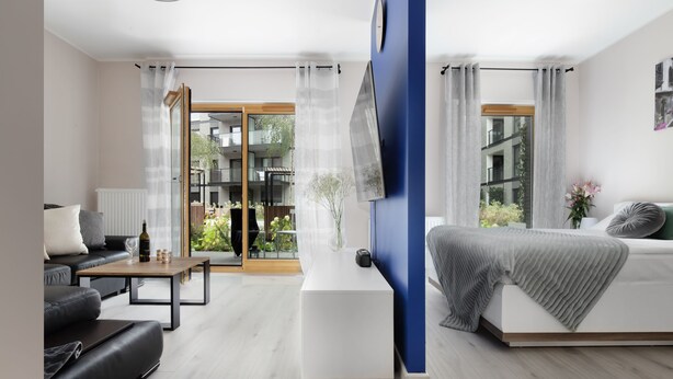 A modern living room with a sofa, coffee table, and a view of a balcony. - Elite Apartments Nadmotławie Prestige (Gdansk)