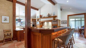 A kitchen with wooden bar stools, a hanging light fixture, and a tiled backsplash. - Brookfield Country House, Pool, 7 bedrooms (Upper Brookfield)