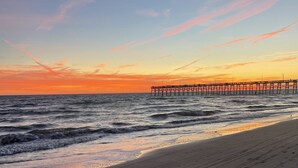 A beach with a pier extending into the water.