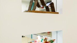 A room with a large mirror reflecting a wooden structure and a colorful abstract sculpture. - Side sea View 3min From the Beach Pj204 (Rio de Janeiro)