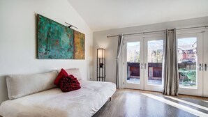 A bedroom with a bed, a painting, a floor lamp, and a view through the sliding doors. - RATES REDUCED! Dogs Welcome! Stunning Views & Unbeatable Location! MainC (Breckenridge)