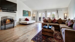 A living room with a fireplace, a sofa, a coffee table, and a television. - RATES REDUCED! Dogs Welcome! Stunning Views & Unbeatable Location! MainC (Breckenridge)