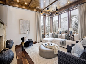 Una sala de estar moderna con un ventanal grande, un sofá, una mesa de centro y una chimenea.