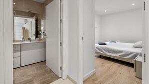A modern bedroom with a bed, bedside table, and a nightstand. - La Vida Sin Limites "B" EMP (Empuriabrava)